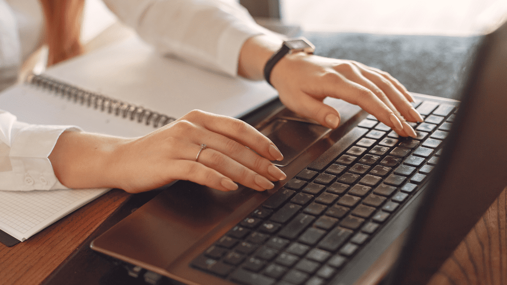 Mani femminili digitano sulla tastiera di un laptop