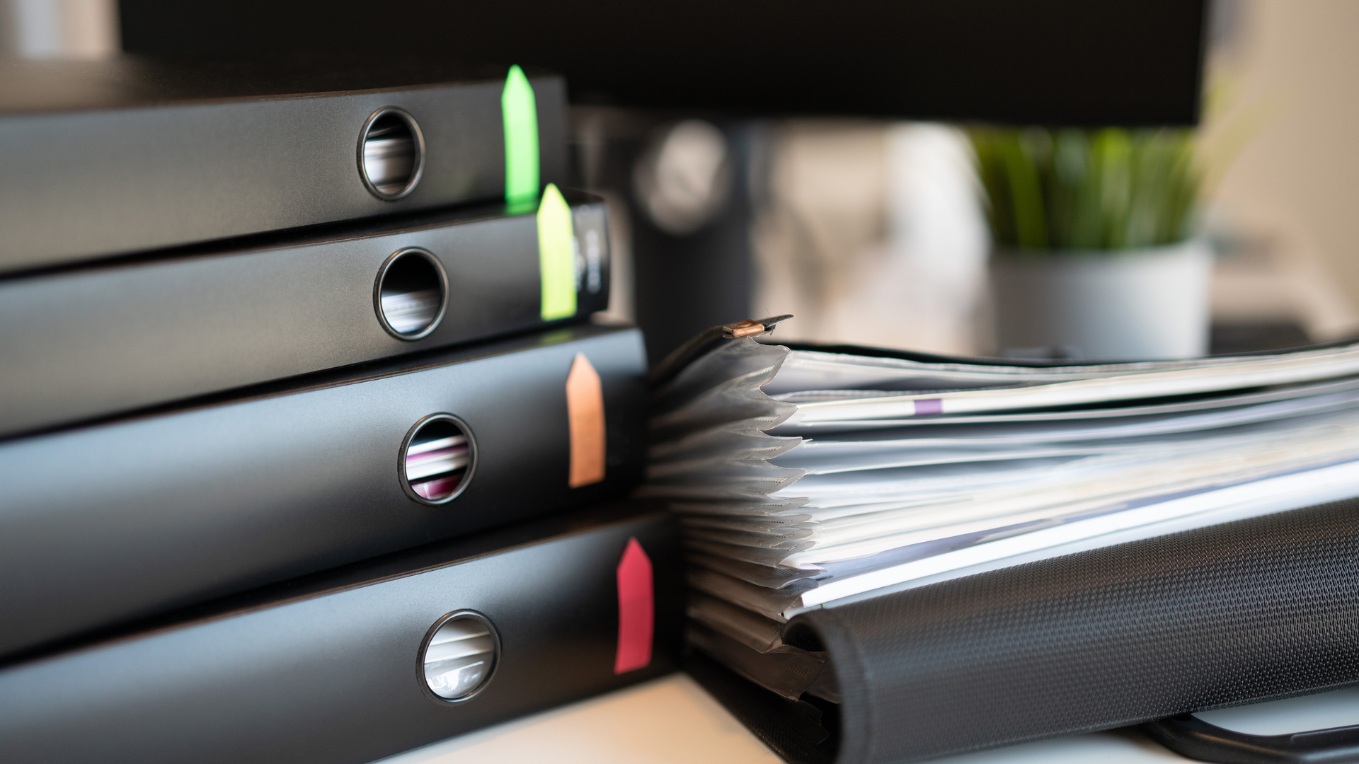 Immagine raffigurante dei raccoglitori per documenti impilati uno sull'altro sulla scrivania degli uffici di Net srl a Torino, nella fase di preparazione del Documento di Valutazione dei Rischi