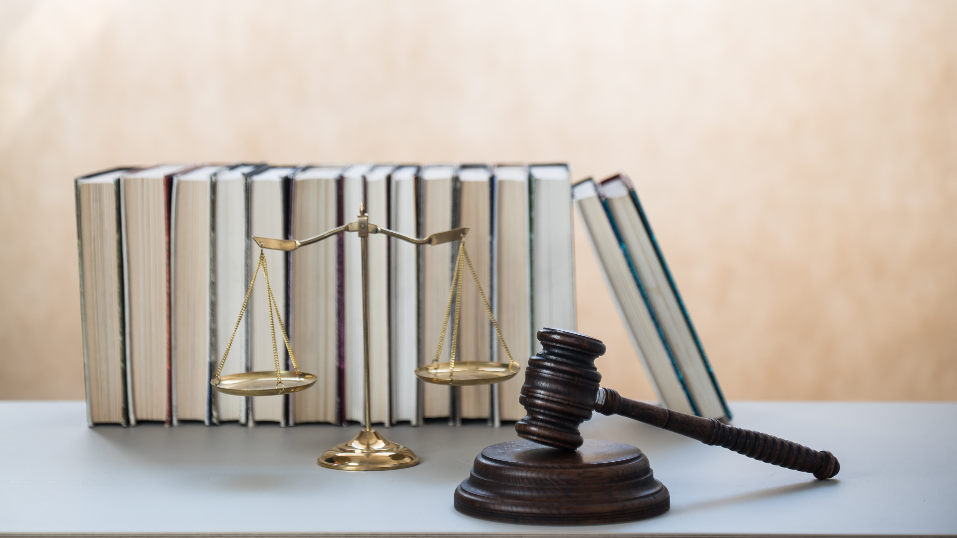 Simboli della legge e della sicurezza sul lavoro: un martelletto da giudice, una bilancia della giustizia e libri, che rappresentano il D.Lgs. 81/08 e il Testo Unico sulla Sicurezza sul Lavoro.