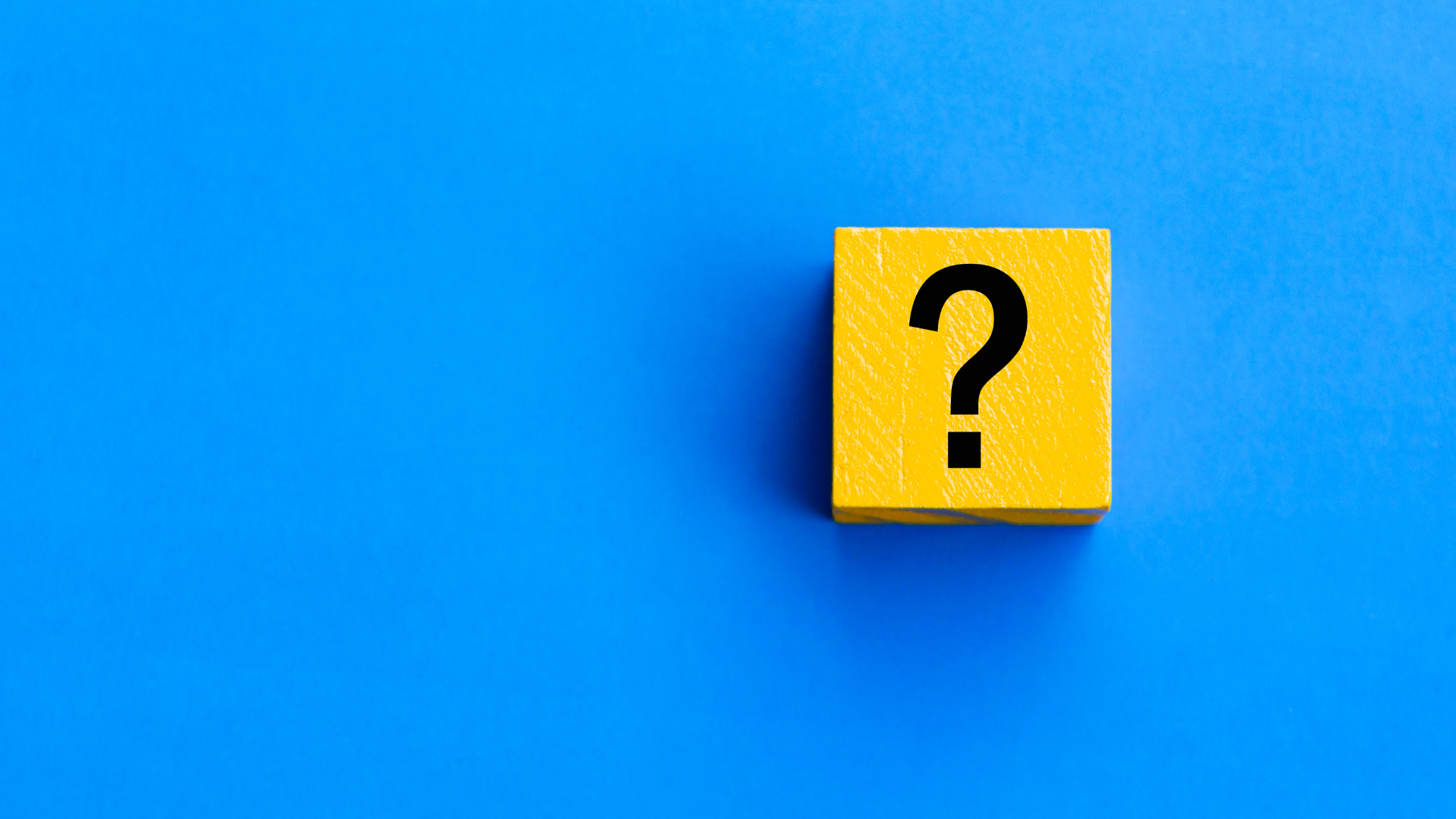 Un cubo giallo con un punto interrogativo nero su uno sfondo blu brillante, che simboleggia le FAQ su sicurezza sul lavoro.